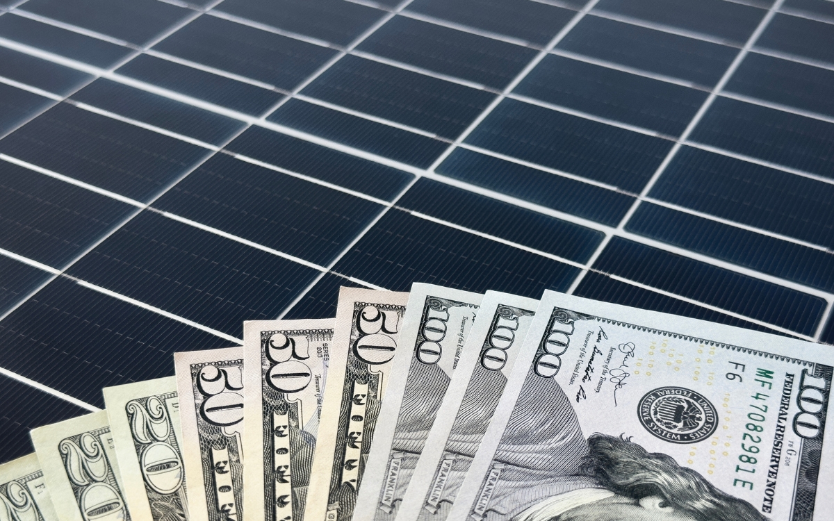 a fanned out dollar bills on a solar panel